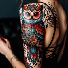 an owl tattoo on the back of a woman's shoulder and upper half sleeve