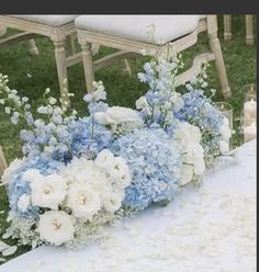 blue and white flowers in vases sitting on a table at a wedding ceremony with candles