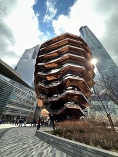 a tall building with lots of wood on it's sides and people walking around