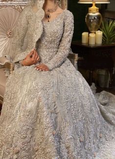 a woman in a wedding dress sitting on a chair