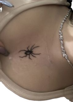 a woman with a spider tattoo on her stomach