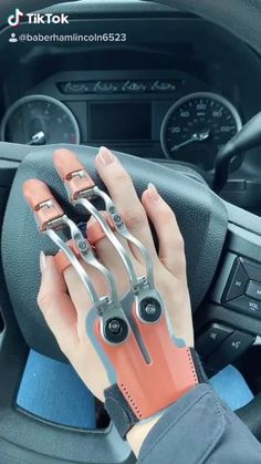 someone is holding scissors in their hand while driving the car with text that reads, every day jobs with my prosthetics