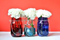 three vases with flowers in them sitting on a table