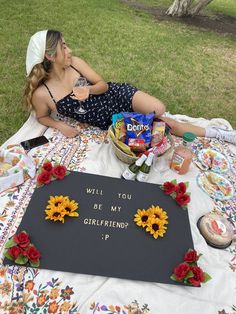 a woman laying on top of a blanket next to a sign