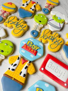 decorated cookies are arranged on a table with the words baby, boy and other items