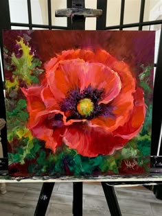 an oil painting of a red flower on a easel