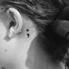 black and white photograph of a woman's ear with the word love behind it