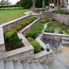 an outdoor patio with stone walls and landscaping