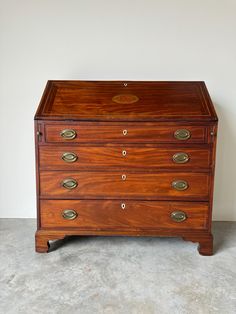 an antique chest of drawers with brass handles