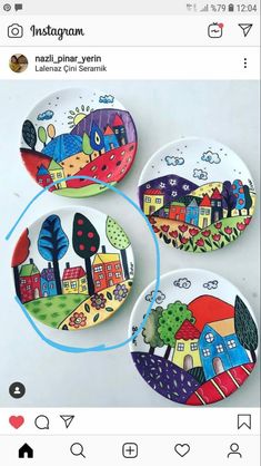 three magnets with houses painted on them, one has trees and the other has buildings