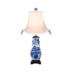 a blue and white vase lamp with a light on it's base, sitting against a white background