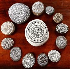 a collection of painted rocks sitting on top of a wooden table next to each other