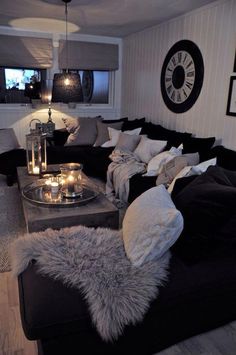 a living room filled with lots of furniture and candles on top of the couches