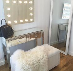 a white bench sitting in front of a mirror