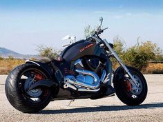 a black motorcycle parked on top of a gravel road