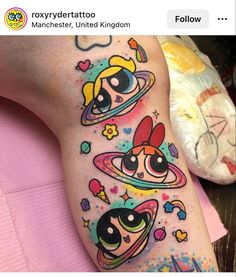 an arm with cartoon tattoos on it and two girls in space around the planet,