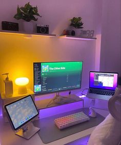 two computer monitors sitting on top of a desk next to a keyboard and monitor screen