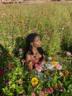 a woman sitting in a field of flowers