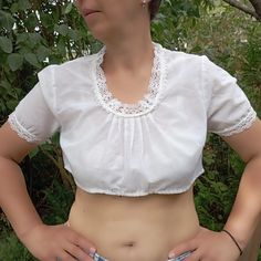 Vintage 80s -90s white Trachten style crop top. Dirndl top decorated with eyelet lace details on neckline and sleeves. Short sleeve October Fest crop top. Traditional Austrian women's clothing. Alpine style blouse M size. From shoulder to shoulder  15" 38cm Bust  42" 107cm Sleeve length  8" 20cm Length  13,5" 34cm. Little defect on fabric see on photo. Crop Top Traditional, Dirndl Style, Crop Top Styles, October Fest, Alpine Style, Style Crop Top, Eyelet Lace, Lace Detail, Womens Clothing Tops