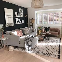 a living room filled with lots of furniture next to a wall covered in pictures and photos