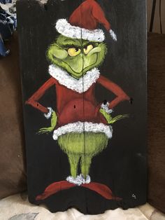 an image of the grin face painted on a wooden sign with santa's hat