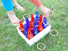 a person standing next to a box filled with blue and red bottles