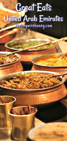 many bowls and pans filled with food on a table