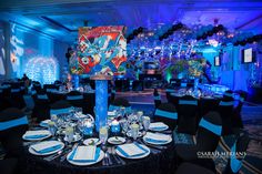 a table set up for an event with blue and black linens