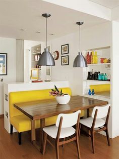 a dining room table with two chairs and a yellow bench in front of the table