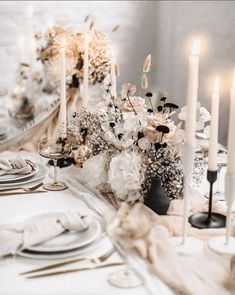 an elegant table setting with candles and flowers