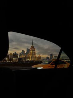 a view from inside a car looking at the city lights and skyscrapers in the distance