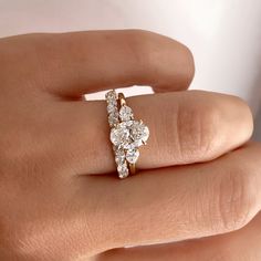 a woman's hand with a diamond ring on top of her finger, showing the side view