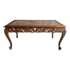 an ornate wooden table with glass top