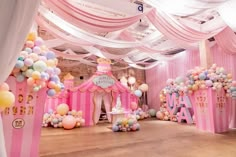 a room filled with lots of pink and white balloons