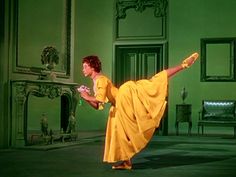 a woman in a yellow dress is dancing