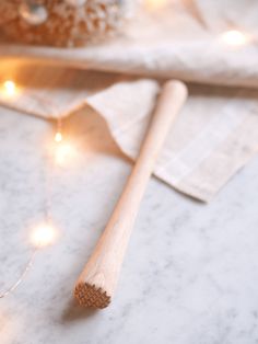 two wooden utensils sitting on top of a table next to some string lights