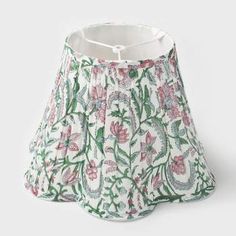 a white lamp shade with pink and green flowers on it