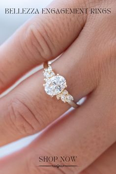 a woman's hand with a diamond ring on her finger and the words belezza engagement rings shop now