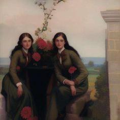 two women sitting next to each other in front of a vase with flowers on it