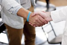 two men shaking hands while standing next to each other