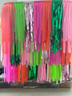 there are many different colored streamers hanging on the wall in front of each other