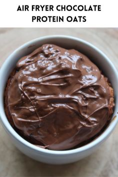 a white bowl filled with chocolate frosting on top of a wooden table and text overlay reads air fryer chocolate protein oats