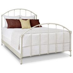 a white metal bed frame with brown pillows