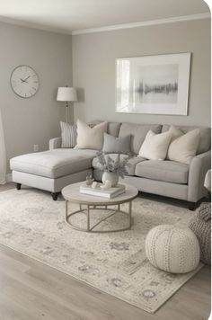 a living room filled with furniture and a clock on the wall above it's windows