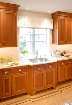 a kitchen with wooden cabinets and white counter tops