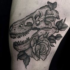 a black and white photo of a dinosaur skull with roses on it's thigh