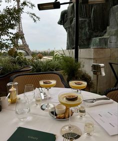 two desserts are sitting on a table in front of the eiffel tower