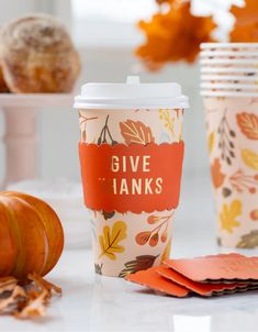 coffee cups with the words give thanks written on them and pumpkins in the background