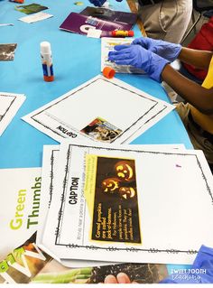 several people sitting at a table with papers and glues on the table, one person is wearing blue gloves