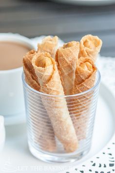 some food is sitting in a glass on a plate next to a cup of coffee